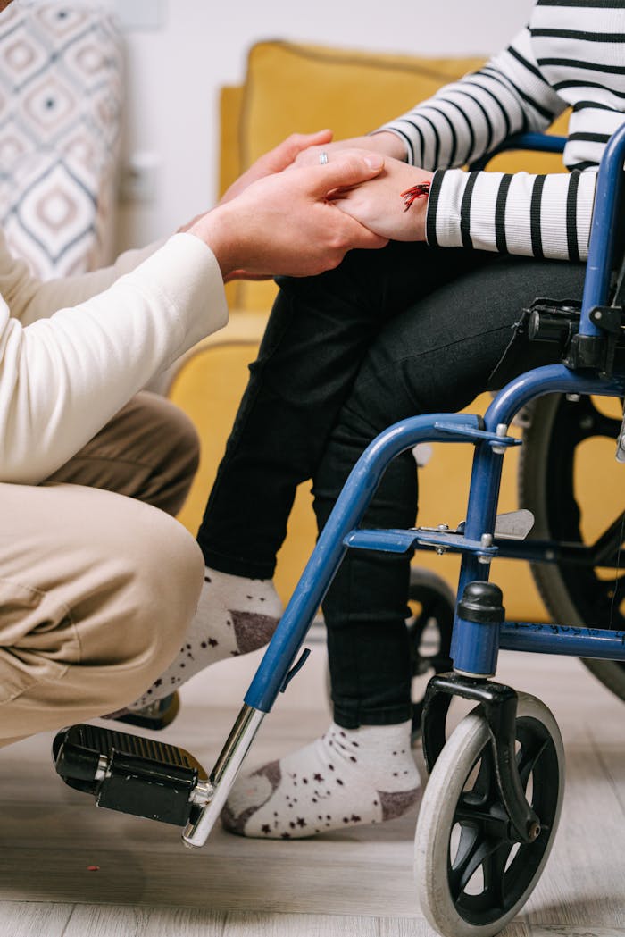 Supportive interaction between caregiver and wheelchair user, showing compassion.